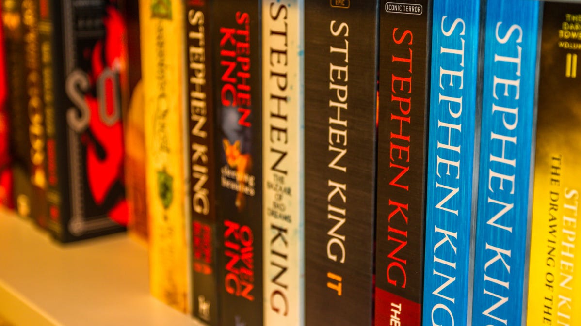 Bir rafta Stephen King ciltsiz kitap koleksiyonu.